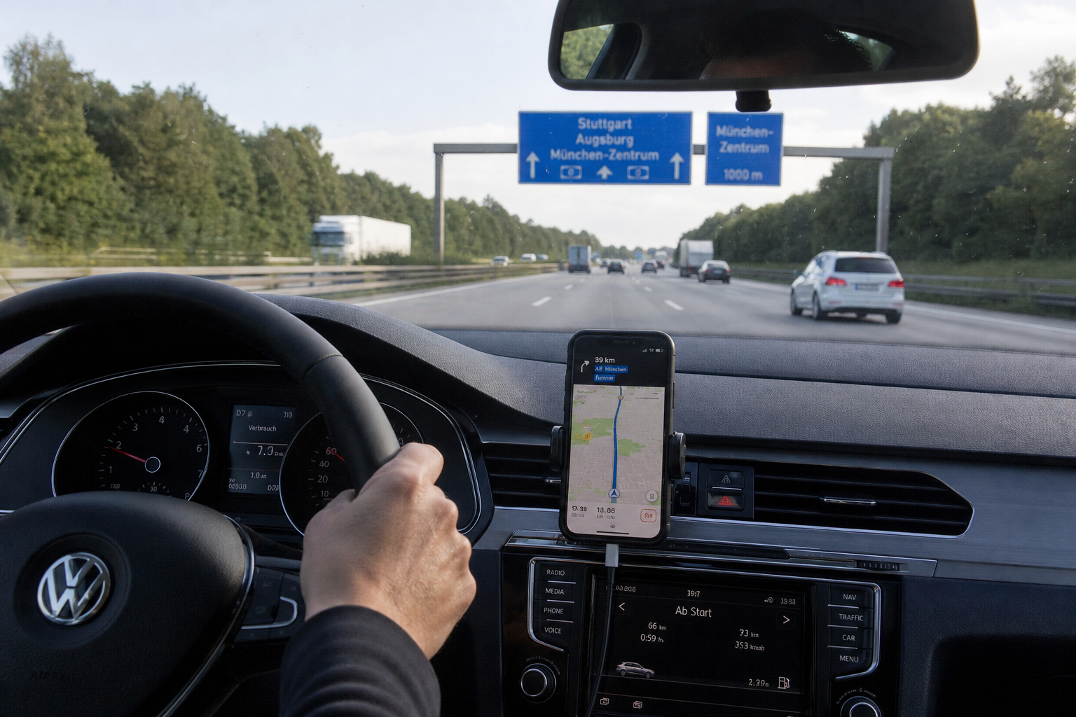 Navigationsroute auf einem Smartphone am Lenkrad während einer Überführungsfahrt